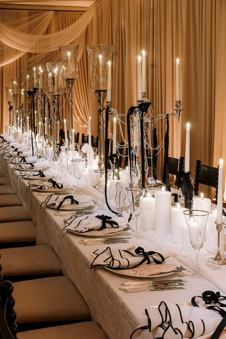 a long table is set with candles and place settings for an elegant dinner or party