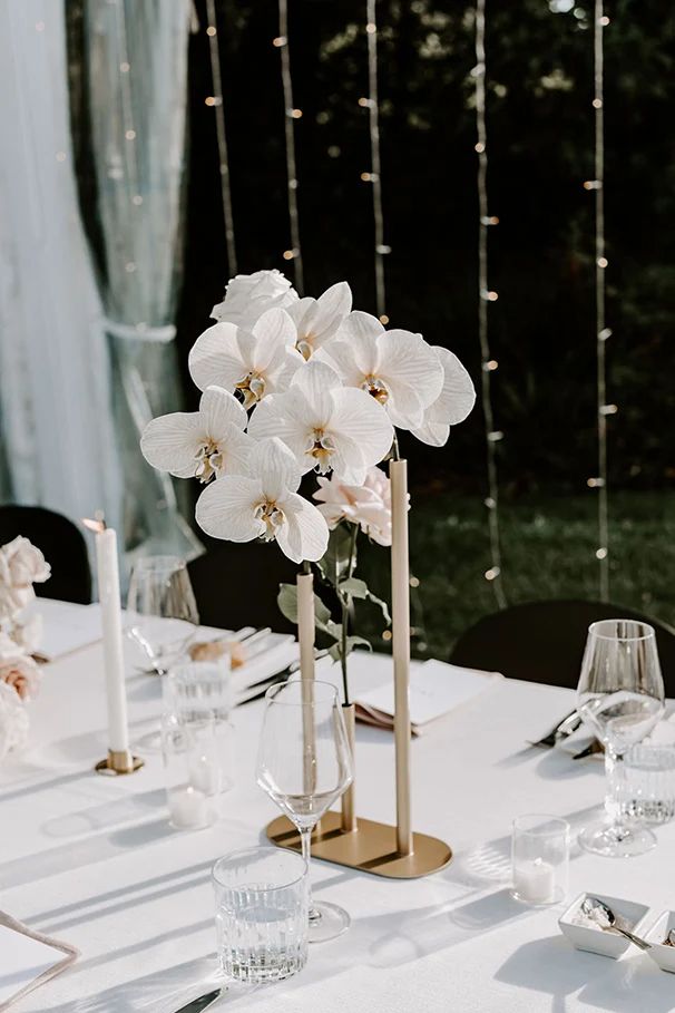 the table is set with white flowers and candles