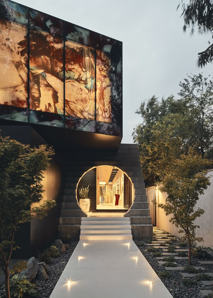 an entrance to a modern house with lights on the side and steps leading up to it