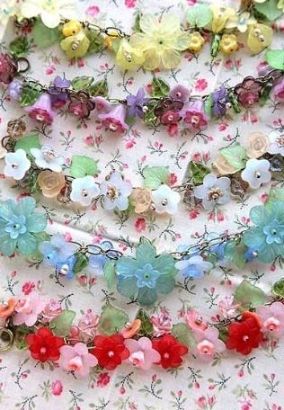 many different colored flowers on a white tablecloth with pink, blue, yellow and red flowers