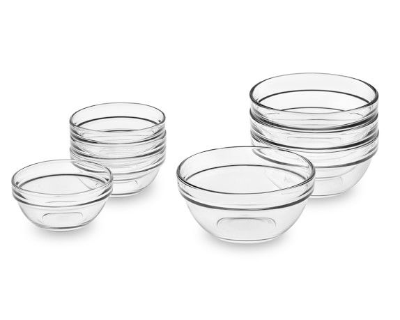 six clear bowls with black rims are stacked on top of each other in front of a white background