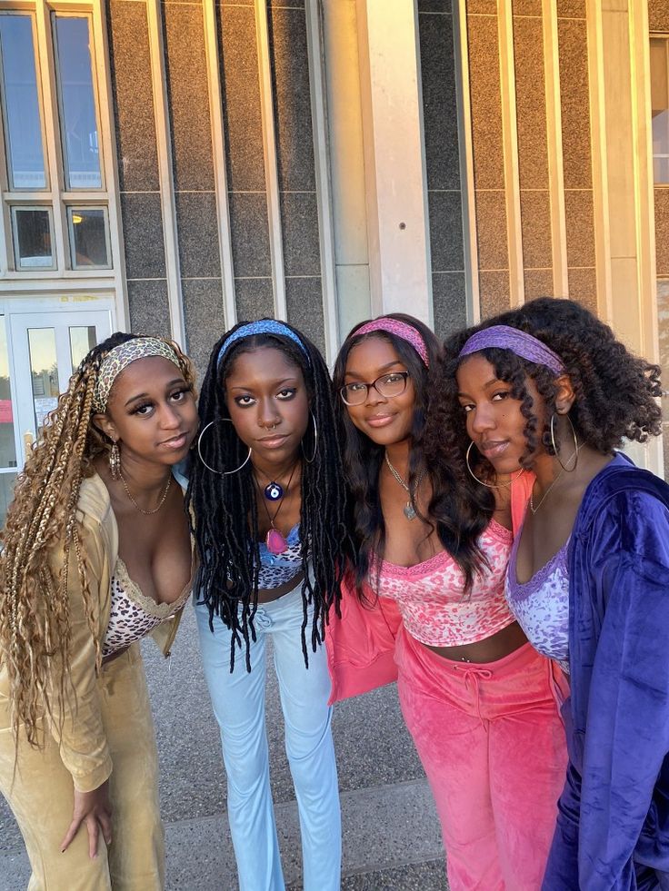 four young women posing for the camera in front of a building