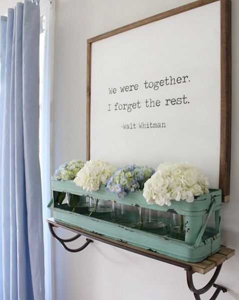 a sign that says we were together i forget the rest next to some flowers on a shelf