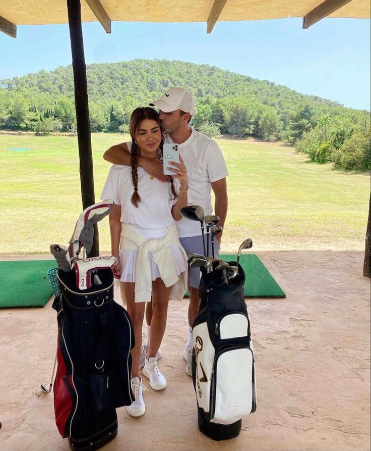 a man and woman standing next to each other with golf bags in front of them