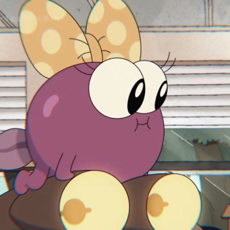 a cartoon character sitting on top of a table with an eyeball in it's mouth