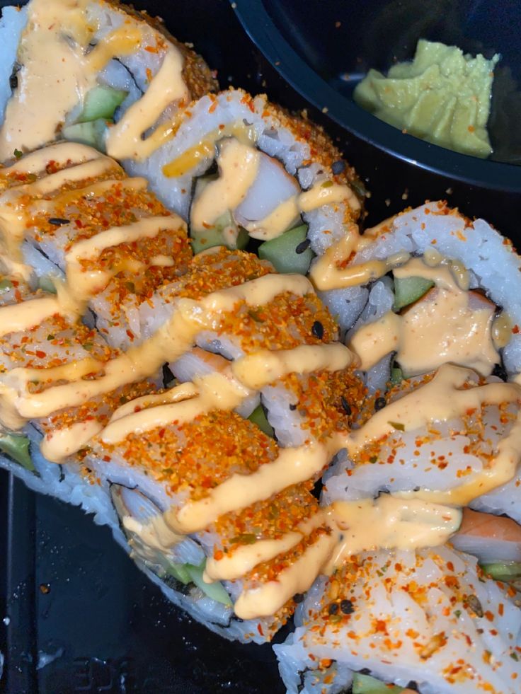 sushi rolls covered in sauce and garnished with lettuce