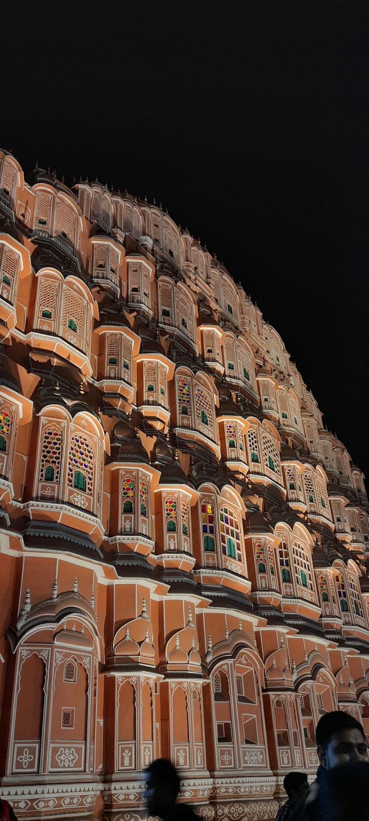 the building has many windows and balconies on it's sides at night