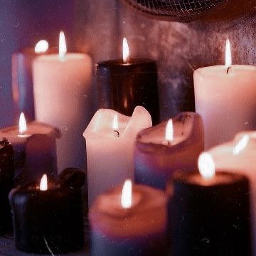 many lit candles are arranged on a table