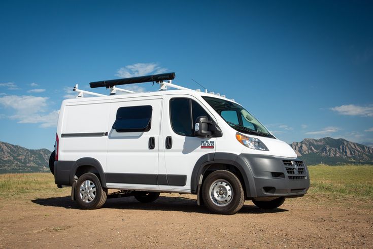 a white van parked on top of a dirt field