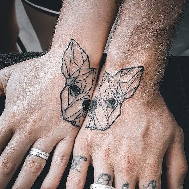 two people with tattoos on their hands and one has a dog's face tattooed on the other hand