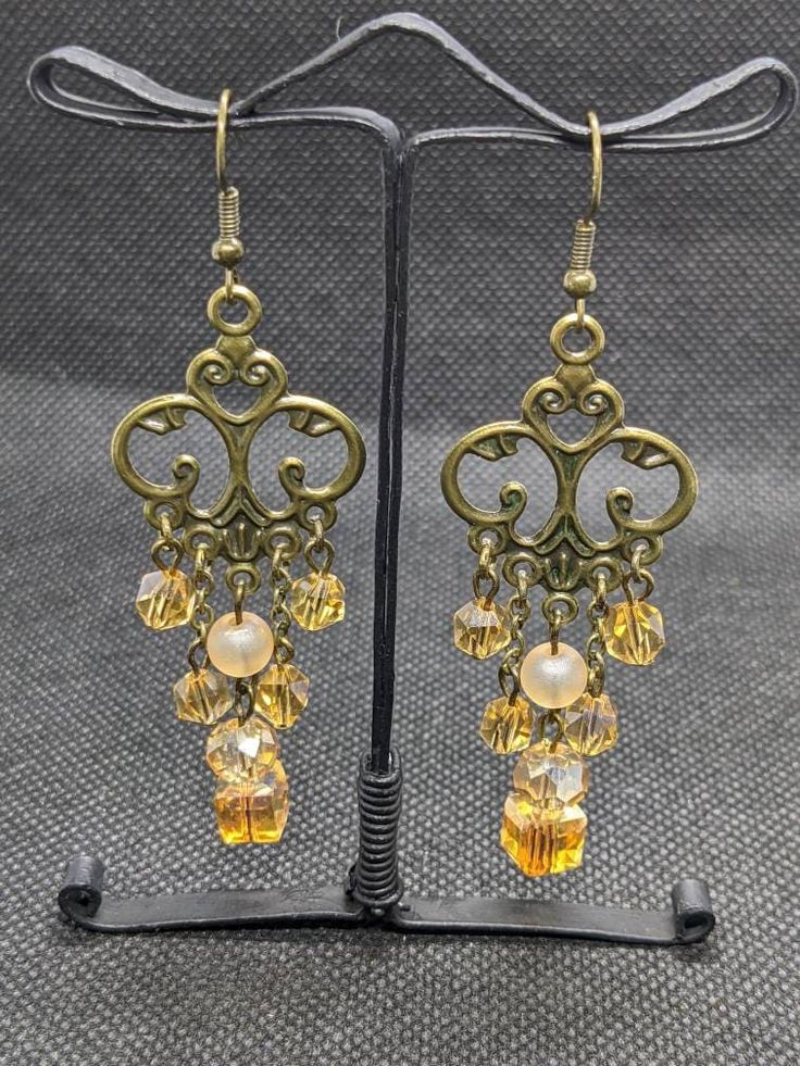 Beautiful earrings made with glass beads and antique bronze. Bronze Brass Drop Chandelier Earrings, Gold Copper Chandelier Earrings, Nickel-free Bronze Chandelier Earrings, Bronze Nickel-free Chandelier Earrings In Brass, Bronze Nickel-free Brass Chandelier Earrings, Beaded Brass Dangle Earrings, Bronze Antique Finish Dangle Earrings, Elegant Bronze Brass Chandelier Earrings, Vintage Brass Beaded Drop Earrings