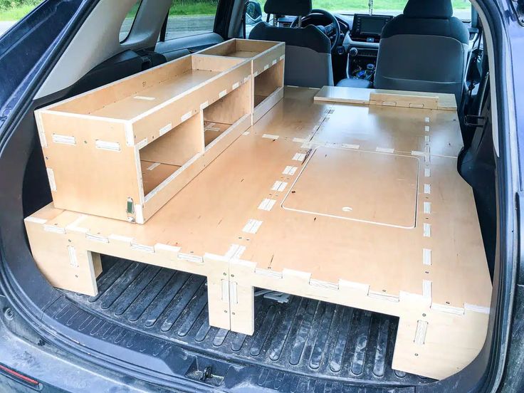 the back end of a car with an open trunk and two shelves in the trunk