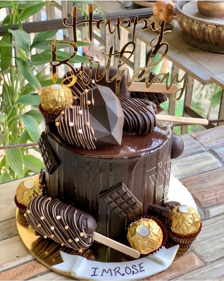 a birthday cake with chocolate frosting and gold decorations