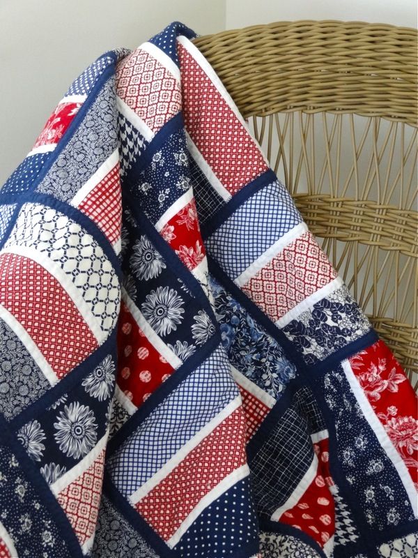 a woven chair with a red, white and blue blanket on it's back