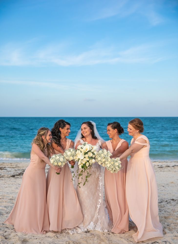 a group of women standing next to each other on a beach