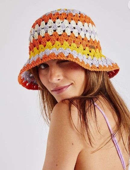 a woman wearing a multicolored crocheted hat