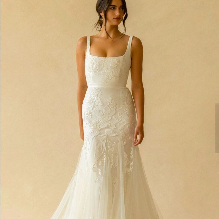 a woman in a white wedding dress posing for the camera with her hand on her hip