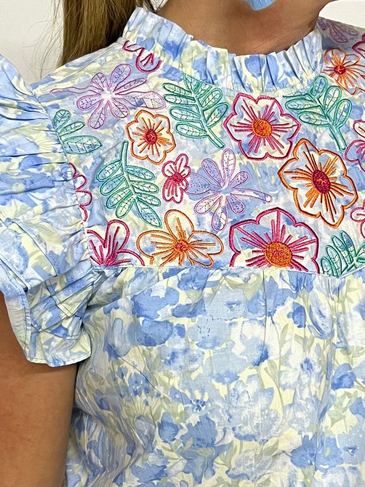 a close up of a person wearing a dress with flowers painted on the front and back