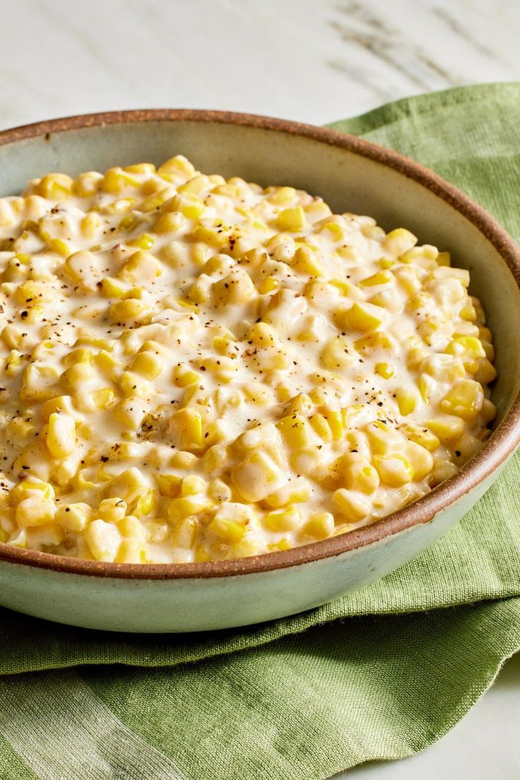 a bowl filled with macaroni and cheese on top of a green napkin