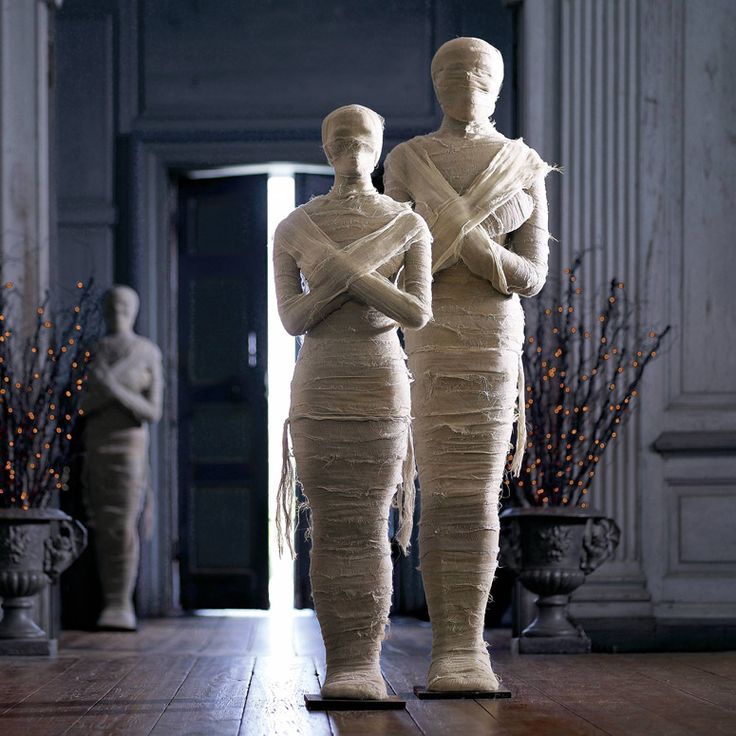 two statues standing next to each other in a room