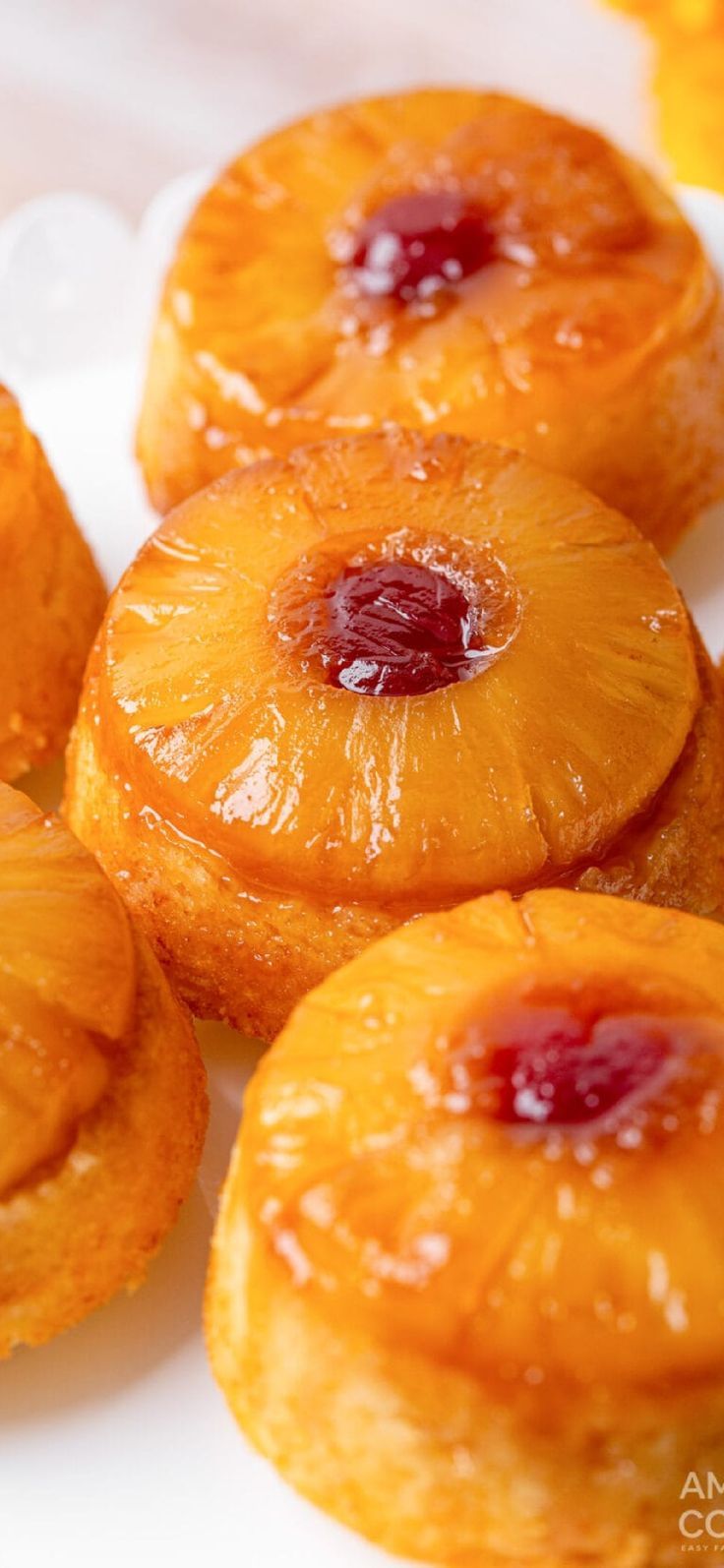 small pineapples on a white plate with orange flowers in the backgroud