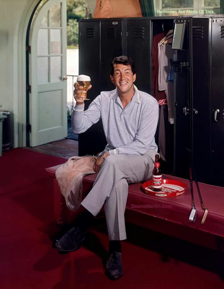 a man sitting on a bench with a beer in his hand and lockers behind him