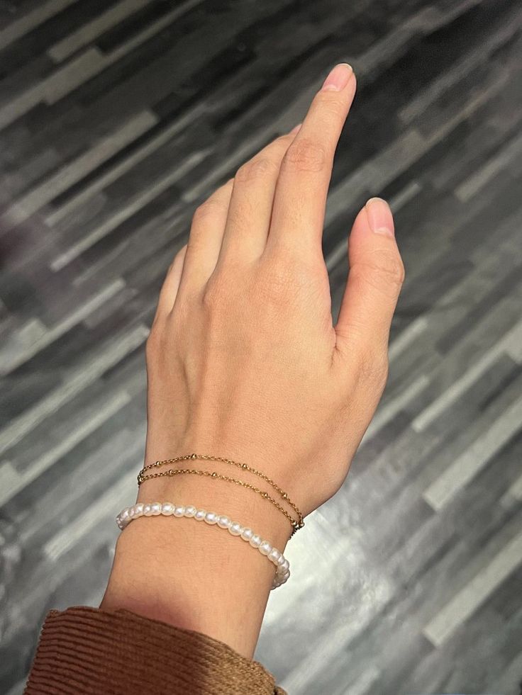 a woman's hand with two bracelets on it