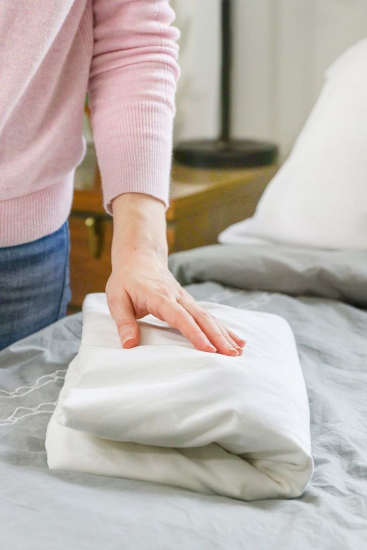 a woman is placing her hand on the pillow