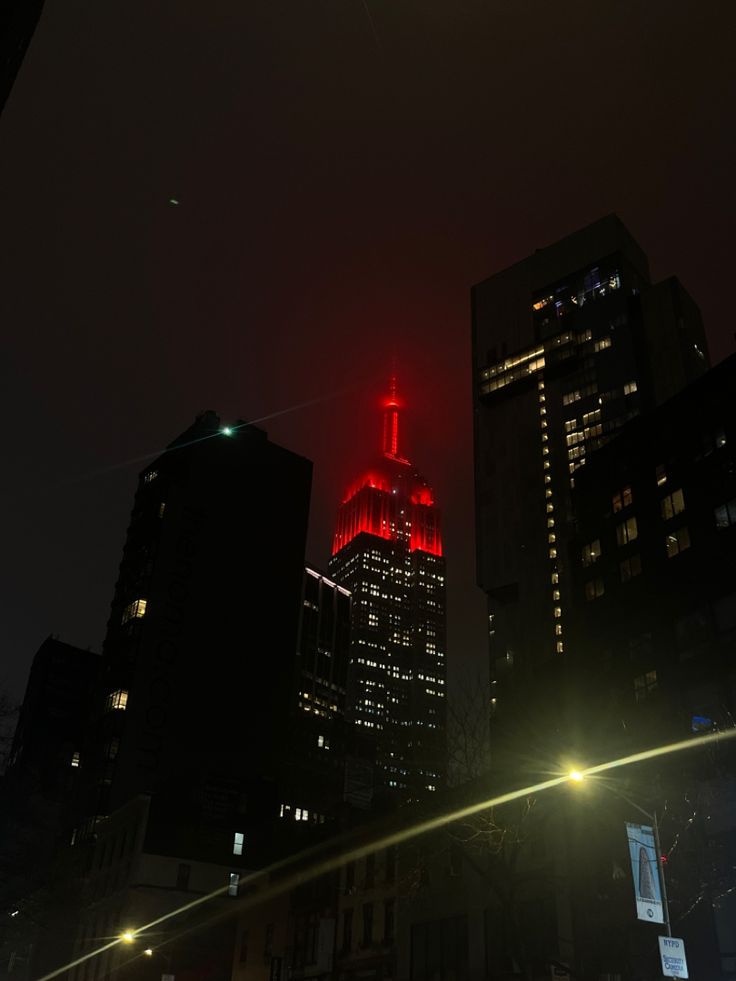 a red lit skyscraper in the city at night