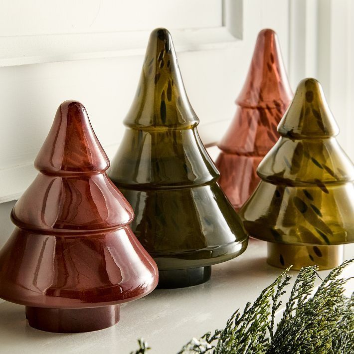 three different colored vases sitting on top of a counter next to a planter