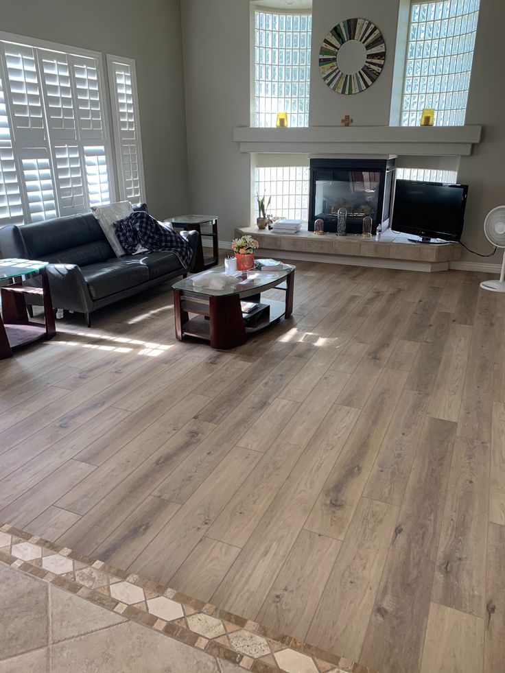 a living room filled with furniture and a fire place in the middle of it's floor