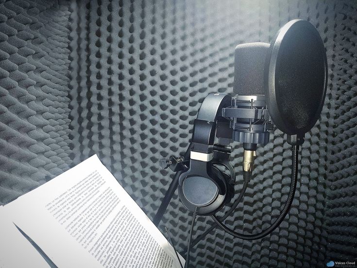 a microphone and headphones sitting on top of a sound recording studio wall with an open book