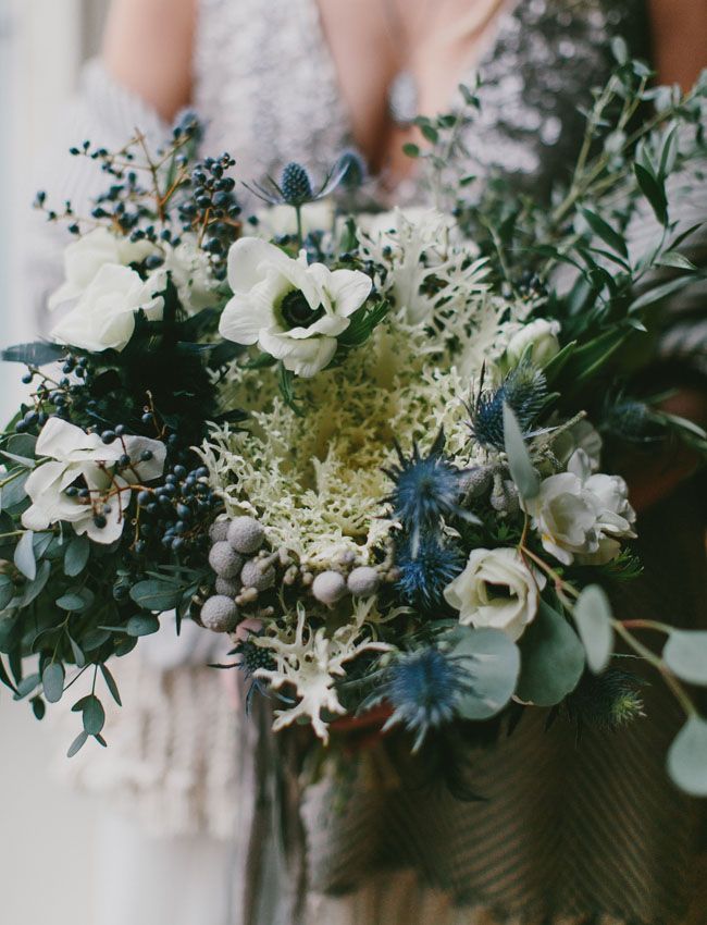 two bridesmaids holding bouquets of flowers and greenery in their hands, close up