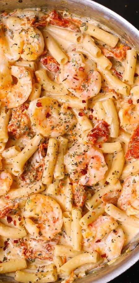 a pan filled with pasta covered in shrimp and sauce