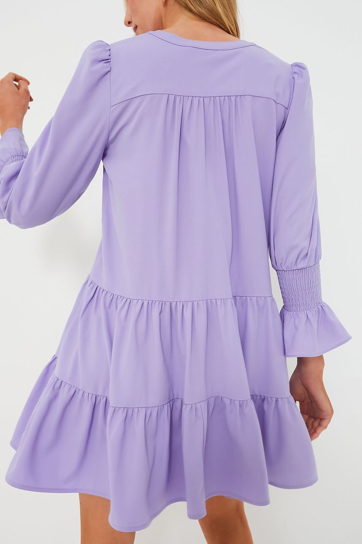 A Tuckernuck fan favorite, the Lilac Kenzo Dress is the mini of the season. Featuring feminine flutter smocked cuffs, a V-neckline and a loose empire waist, this is the most flattering flirty frock! Pair with flats for a casual look or dress it up with heels and statement earrings for date night. V-neckline Long sleeves Elasticated ruffle cuff Swing shape Tiered skirt Mini length Material: 95% Polyester, 5% Spandex Care: Hand wash cold Kenzo Dress, Lilac Dress, Skirt Mini, Tier Skirt, Tiered Skirt, Empire Waist, Get The Look, Statement Earrings, Smocking