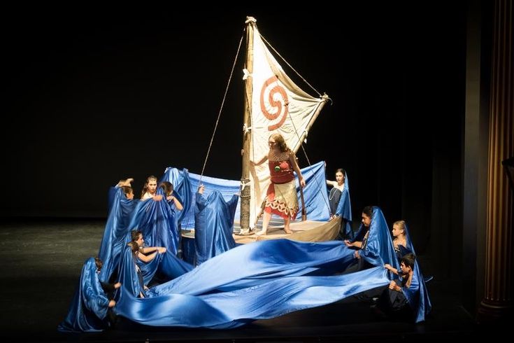 a group of people standing on top of a blue cloth covered boat in the dark