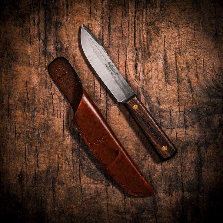 a knife and sheath on a wooden surface