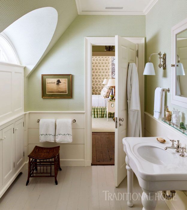 an attic bathroom with green walls and white flooring is pictured in this image from the doorway