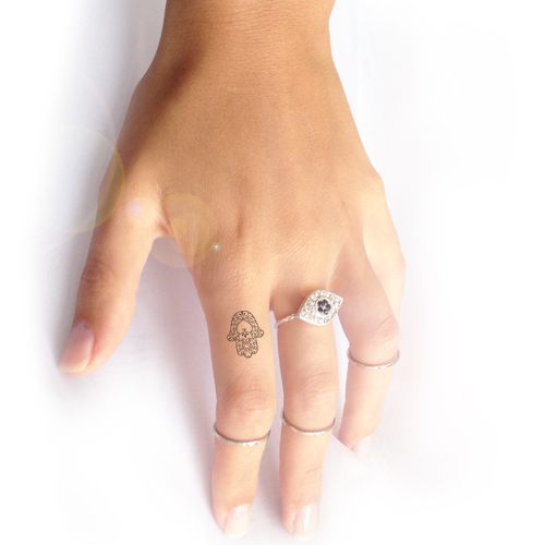 a woman's hand with two rings on it and an evil eye ring in the middle