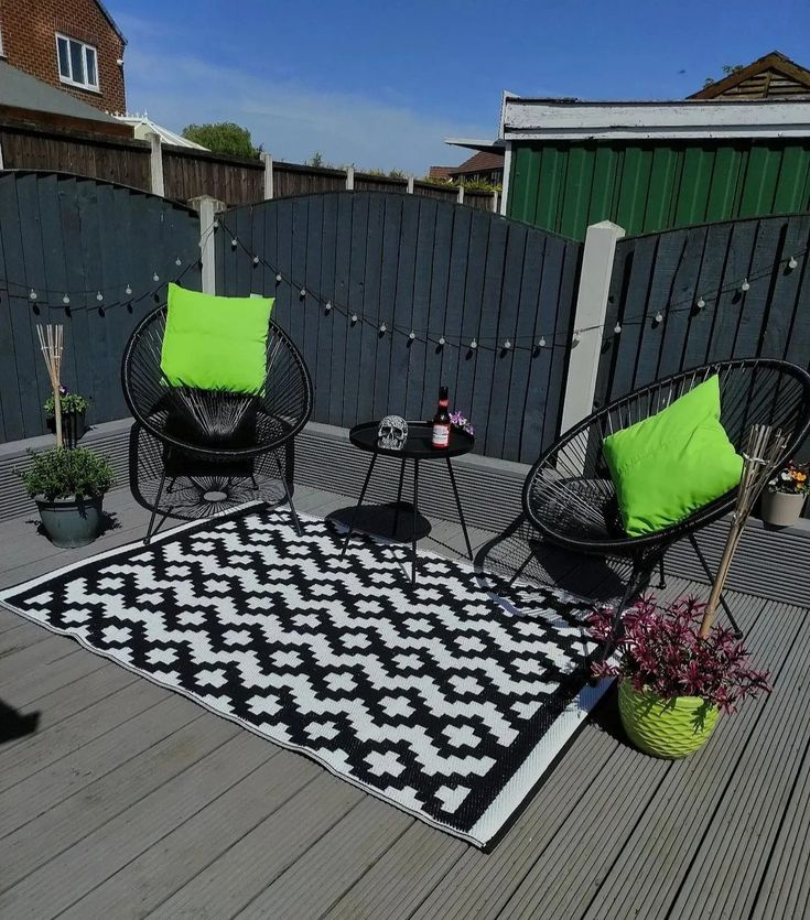 a black and white rug sitting on top of a wooden deck