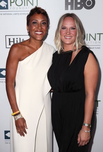 two women standing next to each other on a red carpet