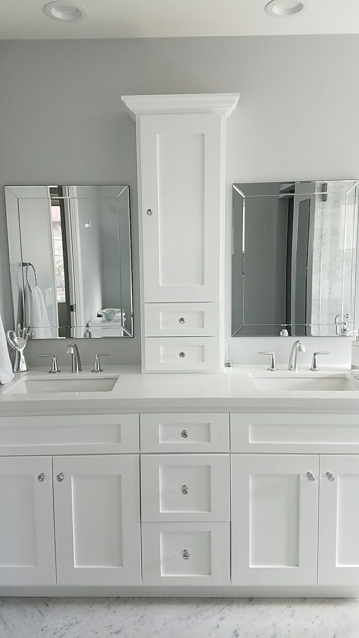 a white bathroom with double sinks and mirrors