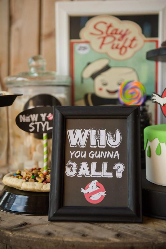 a table topped with cakes covered in frosting next to a sign that says who you wanna call?