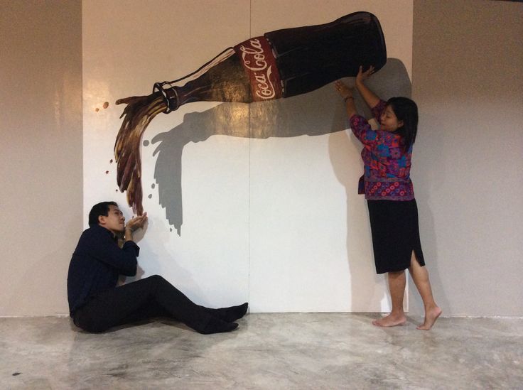 a man and woman are painting a horse on the wall