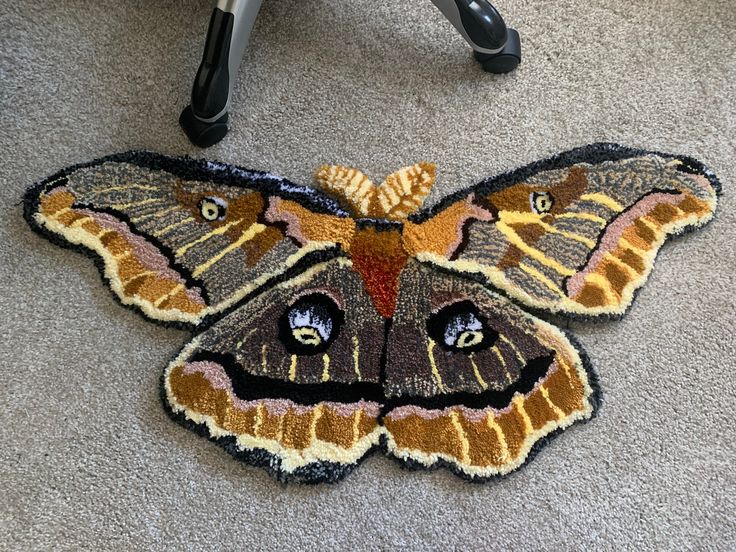 a moth rug is on the floor next to a chair