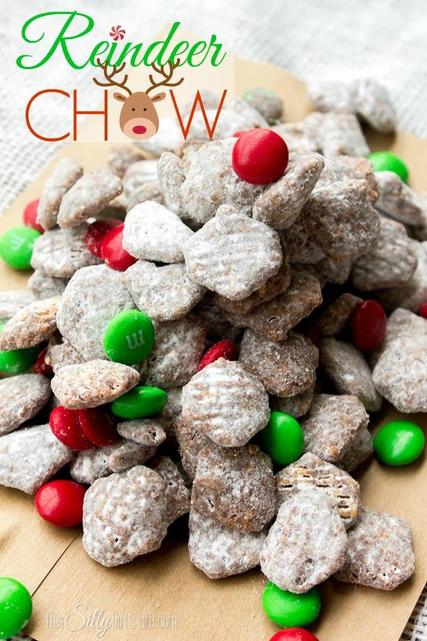 a pile of reindeer chow on top of a wooden cutting board with green and red candies