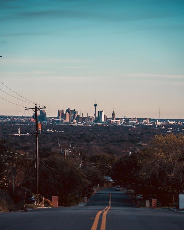 an empty street in front of a city skyline