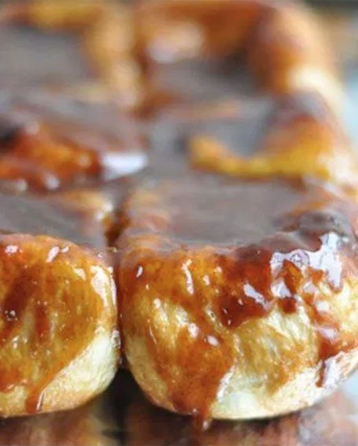 some kind of pastry sitting on top of a pan covered in chocolate sauce and caramel