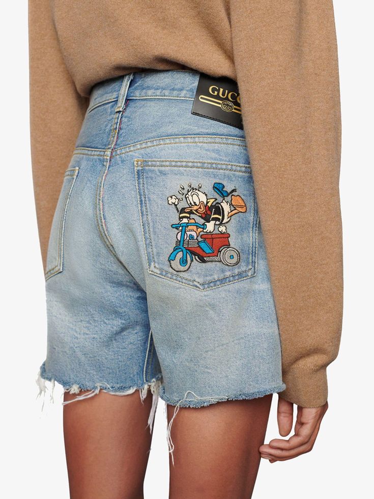 Gucci x Disney Eco Denim Shorts - Farfetch Gucci Summer Shorts, Gucci Summer Bottoms Short Length, Gucci Summer Bottoms In Short Length, Short Gucci Bottoms For Summer, Casual Denim Bottoms With Logo Patch, Casual Denim Blue Bottoms With Logo Patch, Gucci Casual Cotton Jeans, Casual Gucci Blue Bottoms, Casual Gucci Bottoms