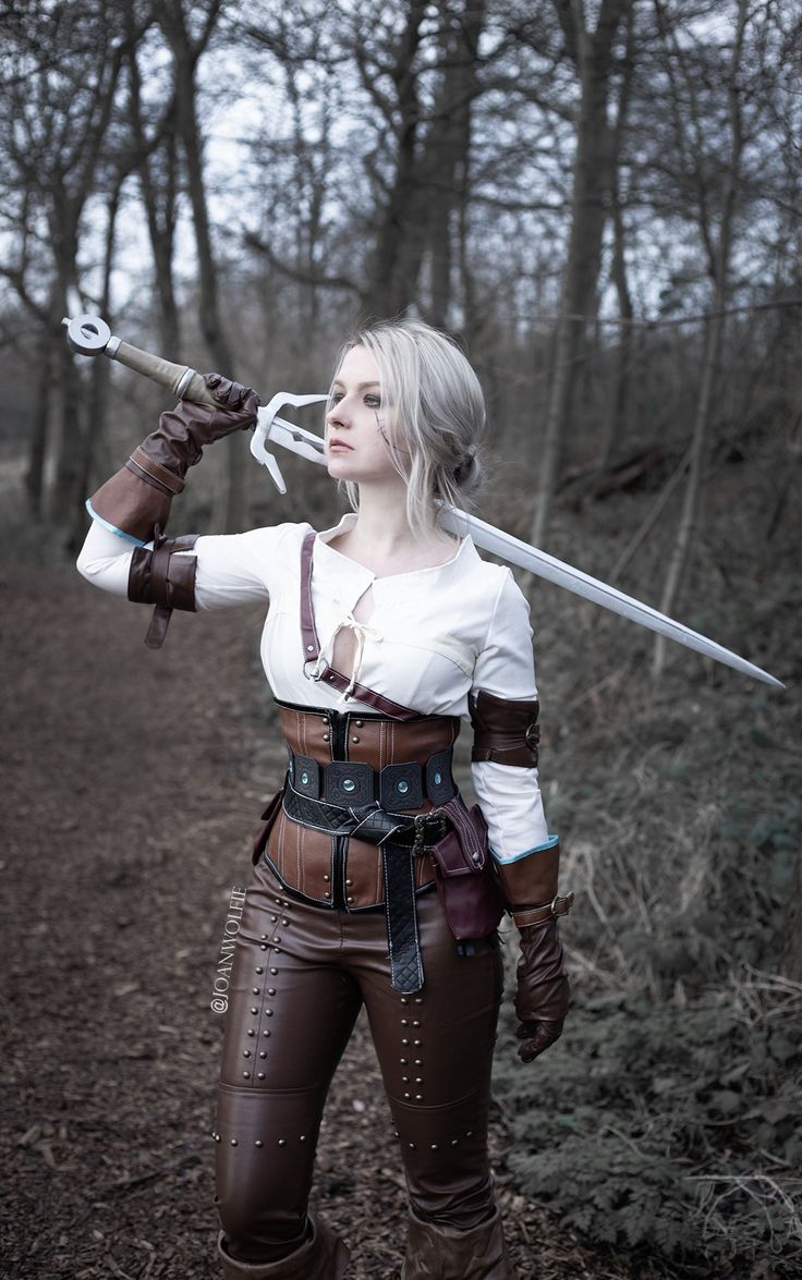 a woman dressed in cosplay holding two swords